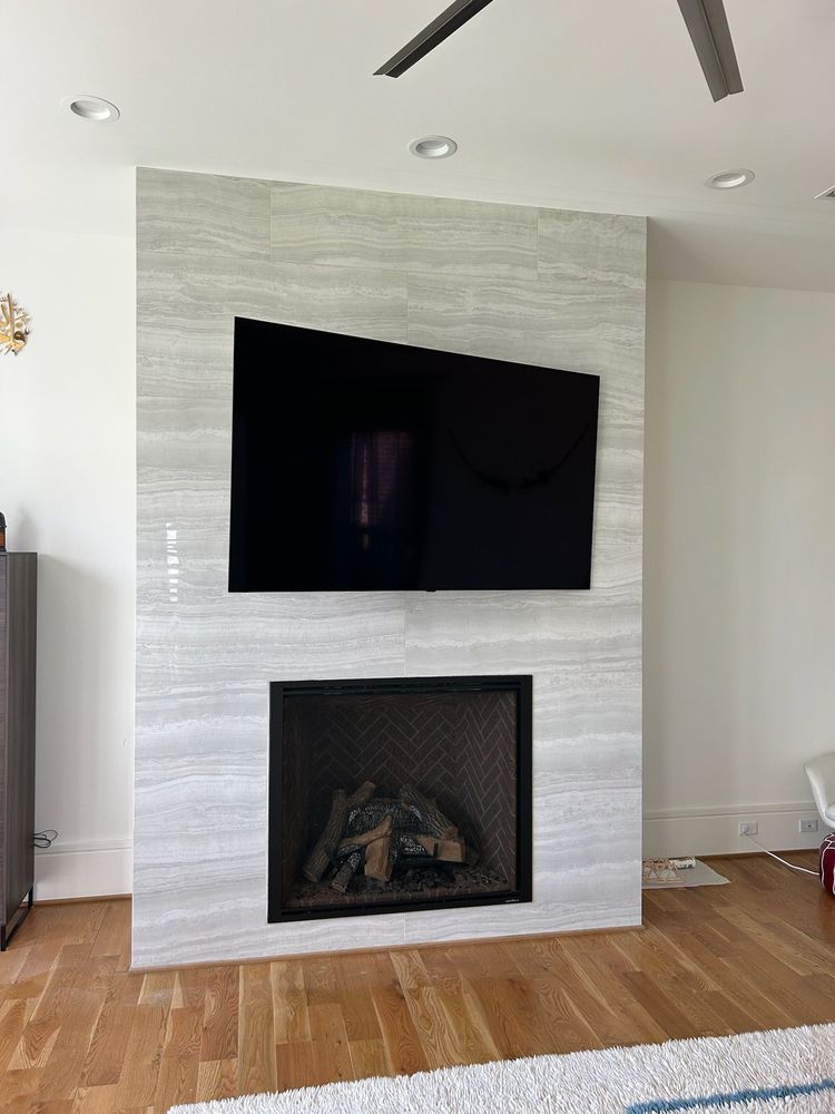 TV mounted on the wall above an electric fireplace